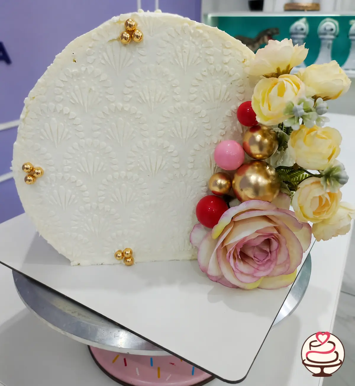 Forward cake blanco con flores y esferas doradas y rosadas