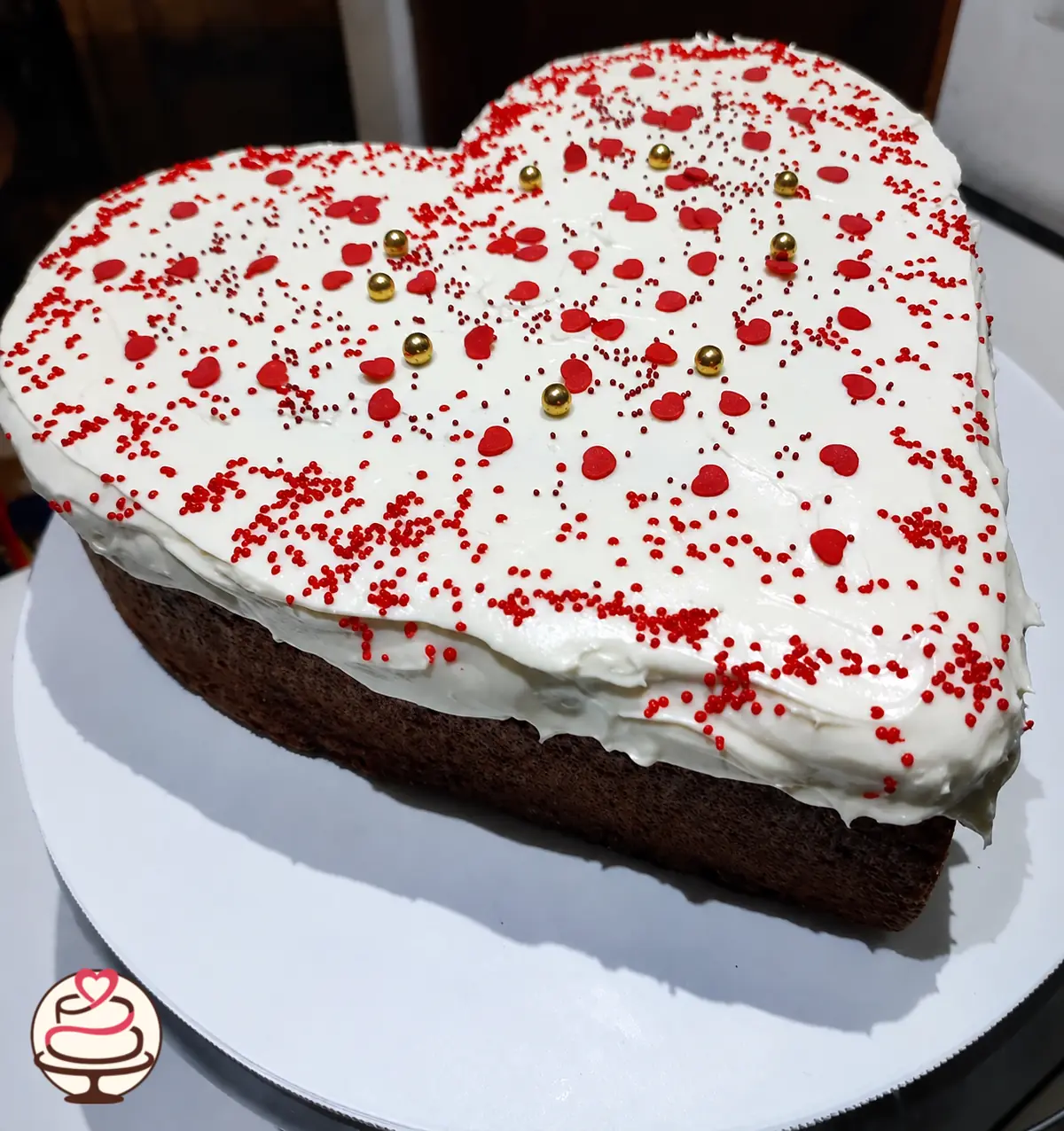 Torta de chocolate en forma de corazón con crema blanca