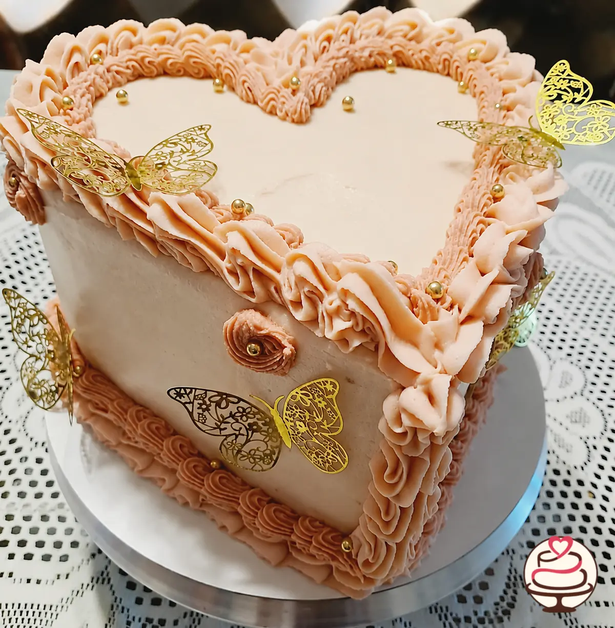 Torta vintage en forma de corazón con buttercream rosado y mariposas doradas